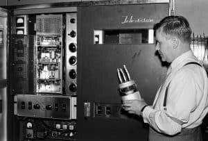 Insinööri Lauri Häkkinen ja RCA tv-lähetin. Yleisradion omalla työpajalla on Yhdysvalloista 29.6.1956 saapunut televisiolähetin viritettävänä ja työtä johtaa insinööri Lauri Häkkinen. Hän seisoo RCA:n televisiolähettimen (tyyppimerkintä RCA TT-2AH) kuvaosakaapin edessä ja hänellä on kädessään kuvalähettimen pääteputki (tyyppimerkintä on 7C24) eli tehotriodi jolla kehitettiin antenniin menevän kuvasignaalin 2 kW teho. Pääteputki oli myös RCA :n omaa tuotantoa. Lähde Yle Elävä Arkisto.